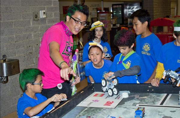 Senior Jerry Cortez works with children from the FIRST Lego League (FLL).