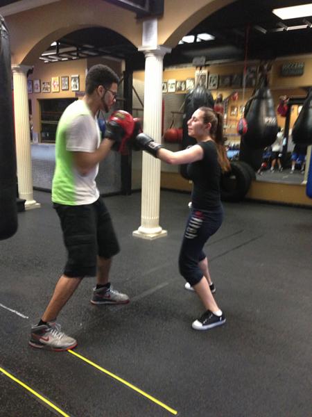 Boxing instructor Ian Porters teaches junior Krkasharian how to throw a hook during her first class. 