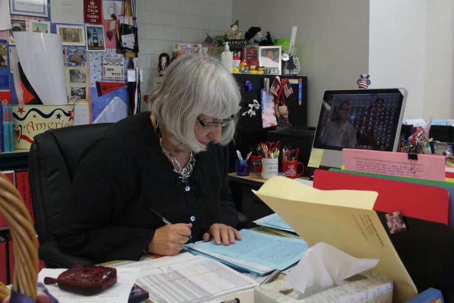 Nancy Witt grades papers at her desk. 