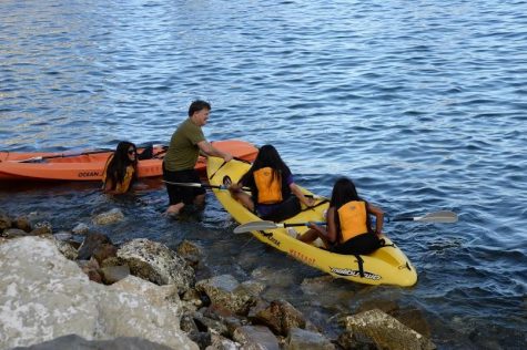 Zamlich helps students who's kayak got stuck on the rocks. 