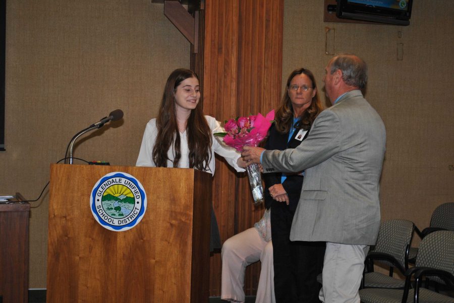  Senior Mary Agajanian accepts congratulatory flowers from Principal Doug Dall and Assistant Supt. Deb Rinder at Tuesdays Board of Education meeting.