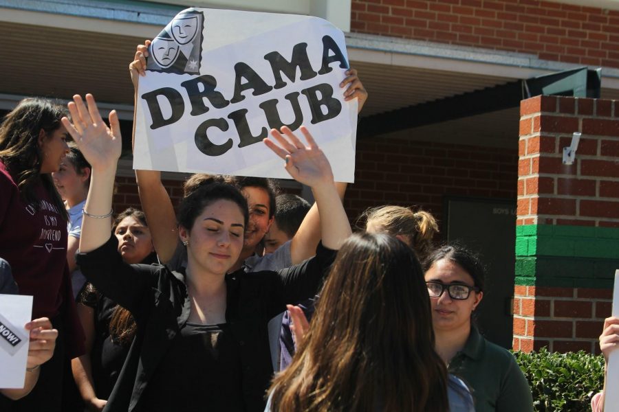 Students display a Drama Club poster