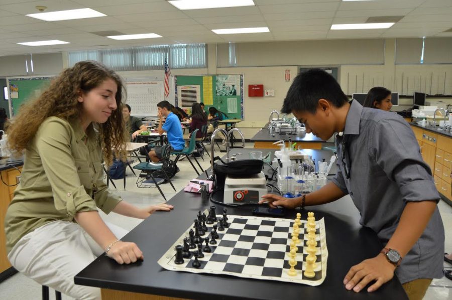 Elizabeth Abramyan, playing with black pieces, and Joshua Valerio, playing with white, contemplate their next steps in their intense game of chess.