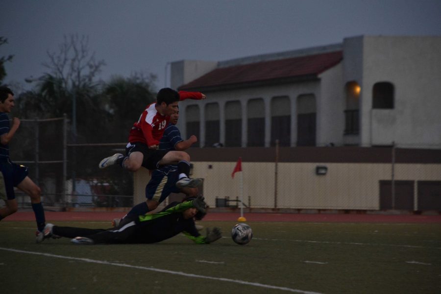 Senior Aram Atamian (19) leaps over the opposing goalie as they both fight for the ball in a match played in 2012. Atamian, who plays for Glendale High, is heading towards the goal as the goalie dives for the ball.