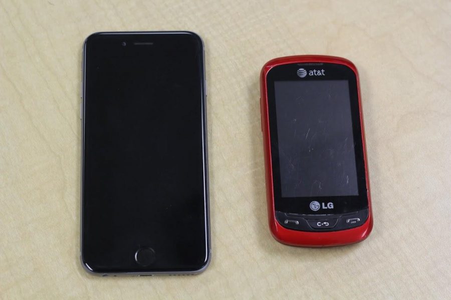 A comparison of the large, thin iPhone 6 smartphone, to a thick, small sliding non-smartphone. 
