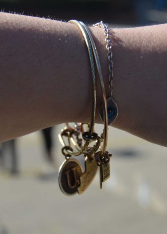 Sintia Babakhani, junior, layers a white gold eye charm bracelet with two Alex and Ani bracelets that add a quick and stylish look to any outfit. “I really love charm bracelets and they make all my outfits look cute,” Babkhani said. “It’s like a signature piece I put on every morning.”  