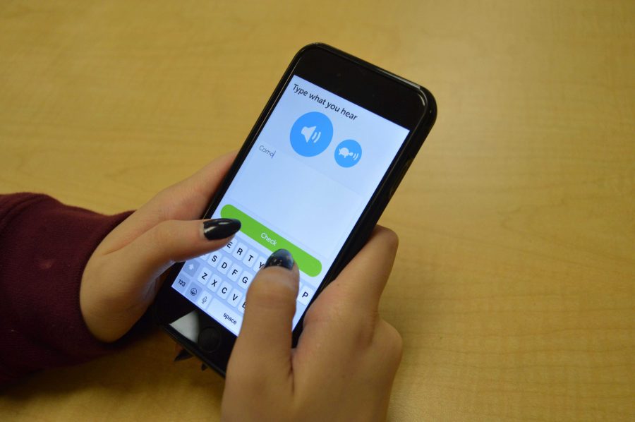 A student practices her Spanish comprehension using Duolingo on her iPhone.
