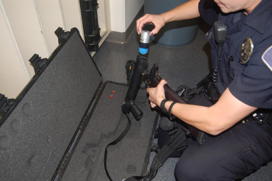 ​Officer Young holding the gun with the blue rubber-headed bullet. This is the gun that is intended for hurting temporarily rather than killing.
