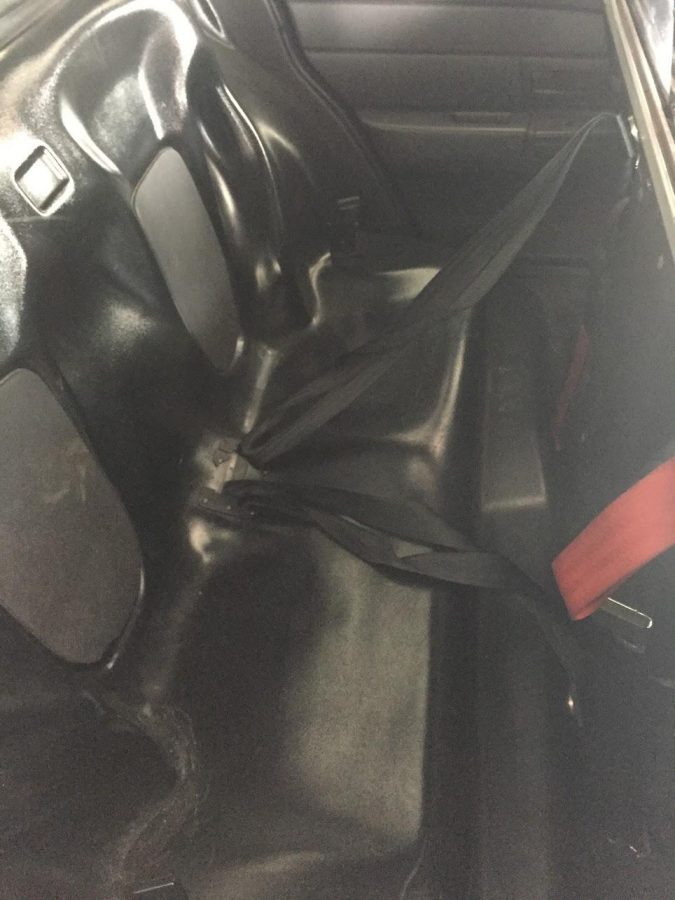 ​The bucket seats of the backseat of a police car. The hard plastic of the seats makes it easier to clean. It is also safer because it makes it difficult for any weapons to be hidden in between crevices.