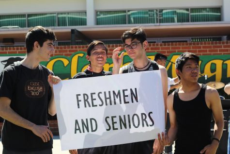 Freshman Courage Channing Kim, Seniors Robert Agajanian, Trevor Norman, and Kamran Jahadi hold up a sign to cue freshmen and seniors to chant as loud as they can.  
