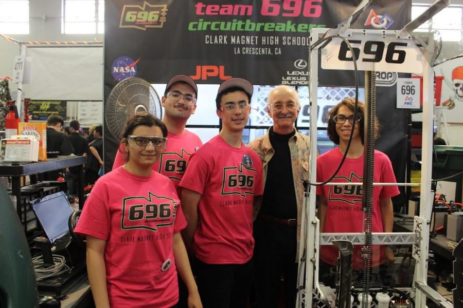 Cynthia Mirzaei, Jack Najarian, Alexander Luke, Woody Flowers, Devon Taylor all stand in line next to Centurion, the robot designed and constructed by Clark’s FIRST Robotics Team 696. 
