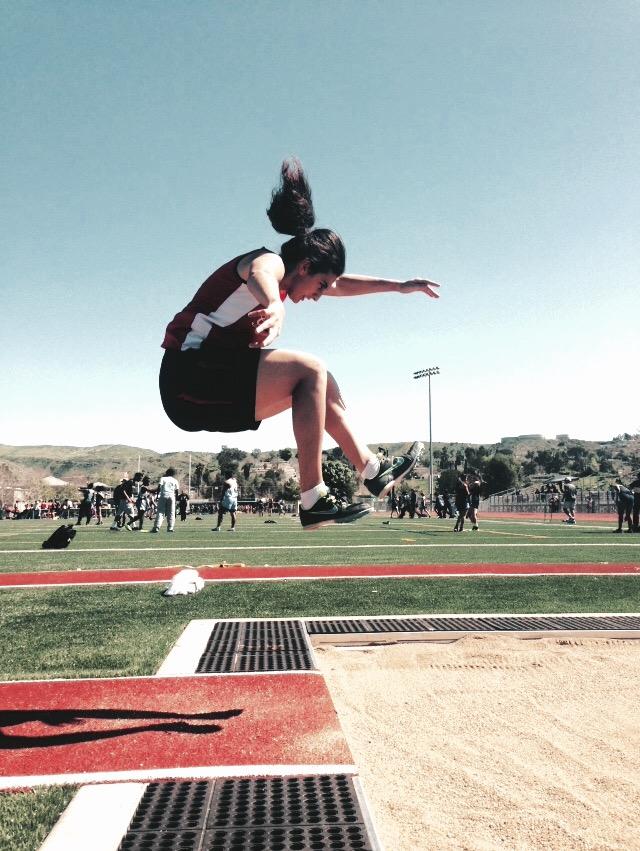Nataly Vardanyan is demonstrating her Triple Jump during a sports event. 
