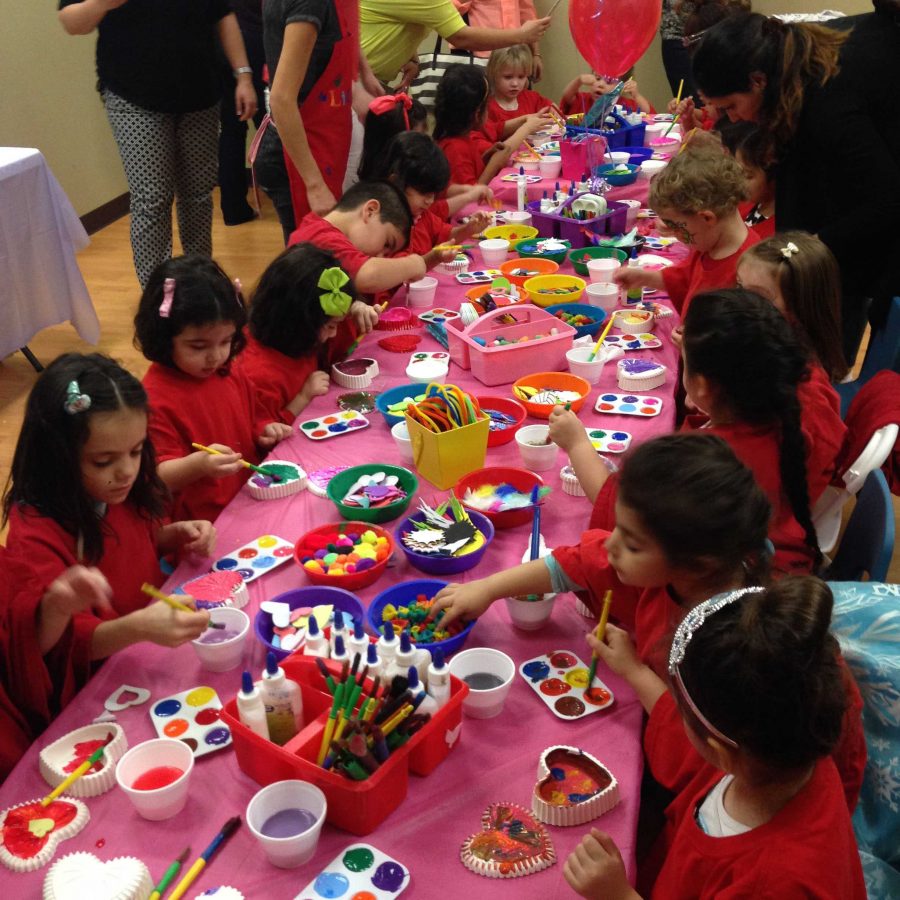 Children decorating heart shaped jewelry boxes. 
