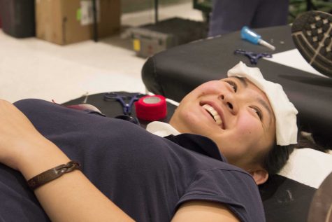 Senior Gennine Lagman laughs as the needle exits her arm.