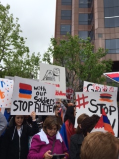 Protesters chant while holding signs made by Armenian Youth Federation members.