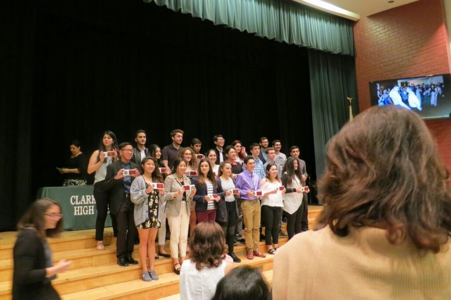 Seniors stand proudly on the stage as they pose with their well-deserved awards.
