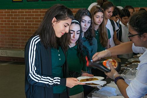 A group of freshmen girls share their opinions on the pancakes as they get in line for seconds.