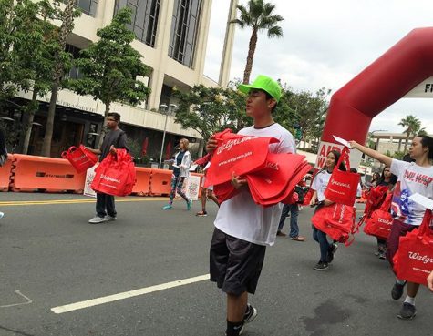 Volunteers carry Walgreens tote bags as a prize for participants