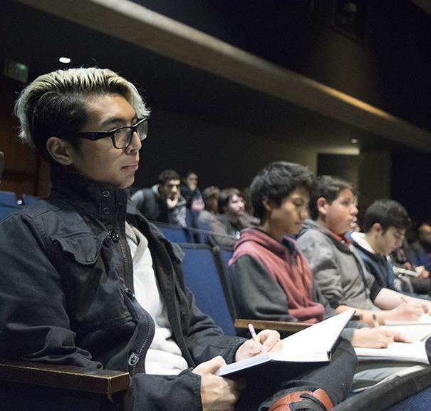 Junior Jarred Lima draws in his sketchbook, along with other students, during the panel.​