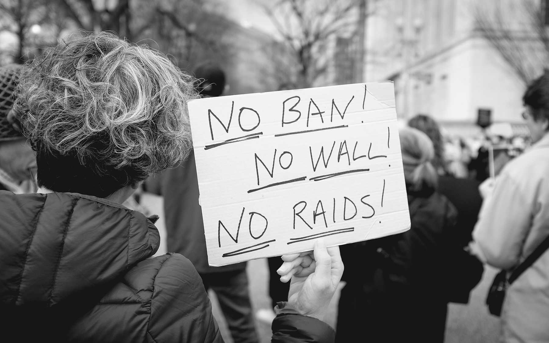 A protester holding a sign against Trump's executive order.
