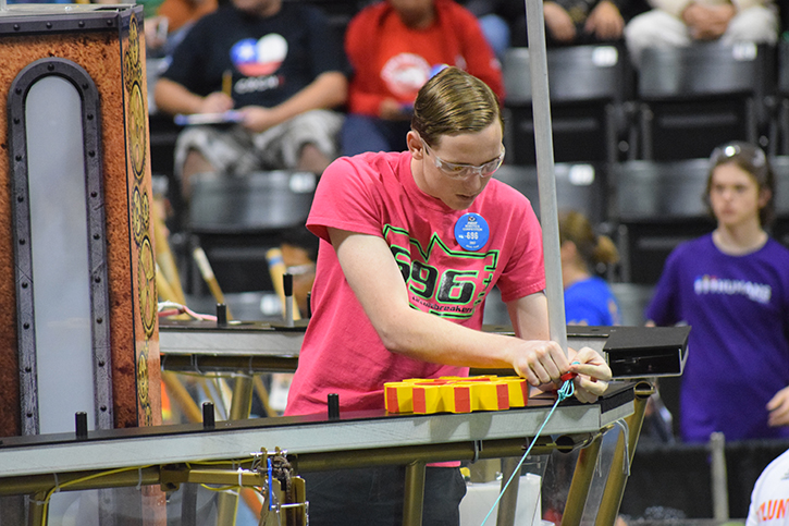 Sophomore Samuel Thompson releasing the rope during the final 20 seconds of the match to let the robot climb for a 50 point bonus.