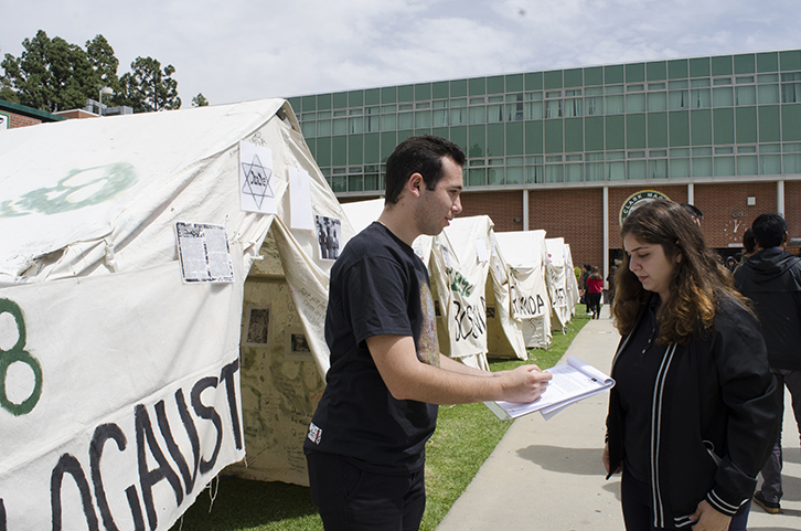 Senior John Bandek tells junior Lara Tolmajian to sign the petition.