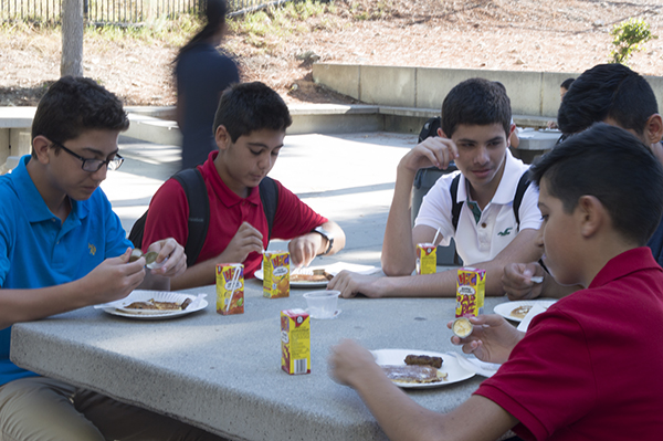 A group of freshman are enjoying their pancakes. 