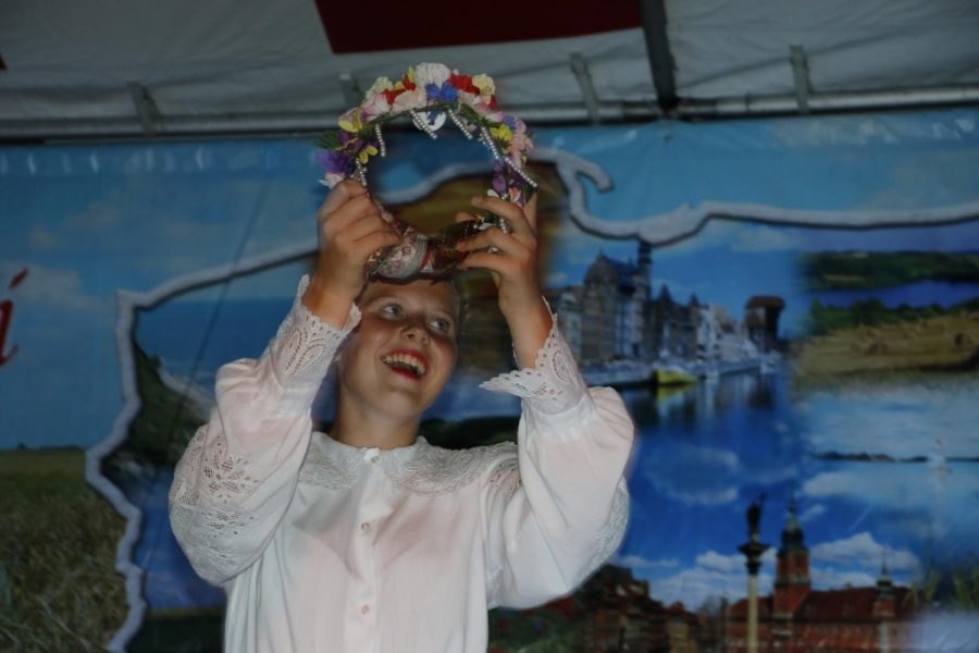 Victoria Borkowski lifting her flower crown in the “Wianki” performance.