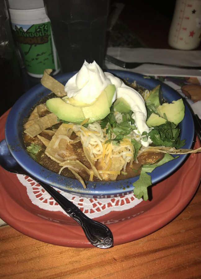 The chicken tortilla soup topped with sour cream 
