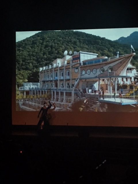 Clark student performing a beautiful dance with photos of  Artsakh in the background.