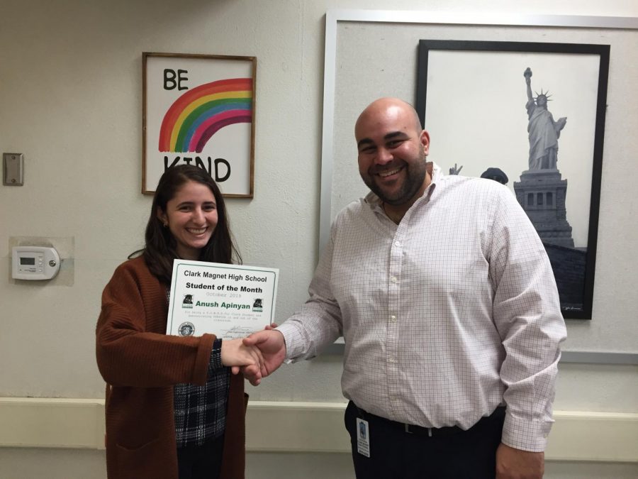 Junior Anush Apinyan shakes hands with US History teacher Patrick Davarhanian to receive her award. 