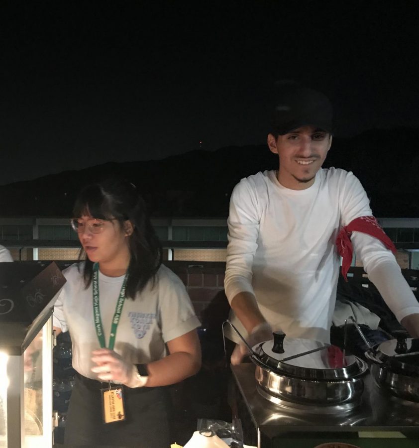 Tyra MarieNicole Quiachon and Martun Gevorgyan pass out nachos and churros to students as Furious 7 plays in the background.