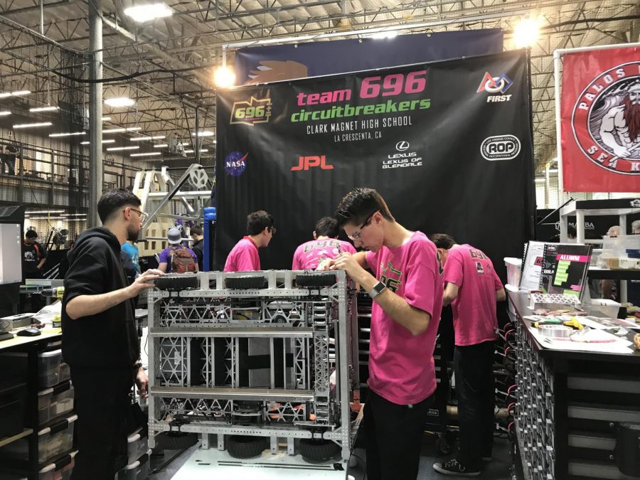 The+696+team+works+on+the+robot+during+the+competition+to+make+sure+all+parts+of+the+mechanism+are+functioning+properly.