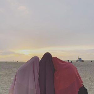 Fatma Abdelrahman,  Moyassar Qwaider, and Fatima Mohtadi proudly wear their khimars (hijabs) by the beach.  