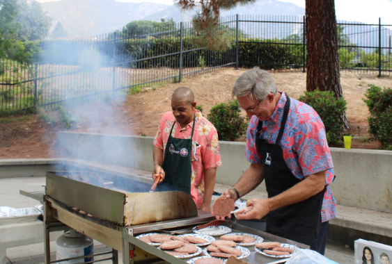 Mr. Doom and Dr. Pruitt flipping burgers for Senior Barbeque