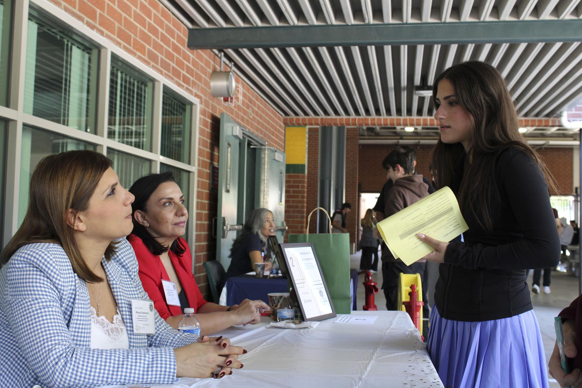 Senior Nathalie Vartan speaking to Margo Kazaryan and Lilit Harutyunyan on table 2