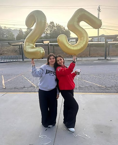 Anahit Karapetyan and Gayane Gevorgyan pose with 25 balloons, representing their graduation year.
