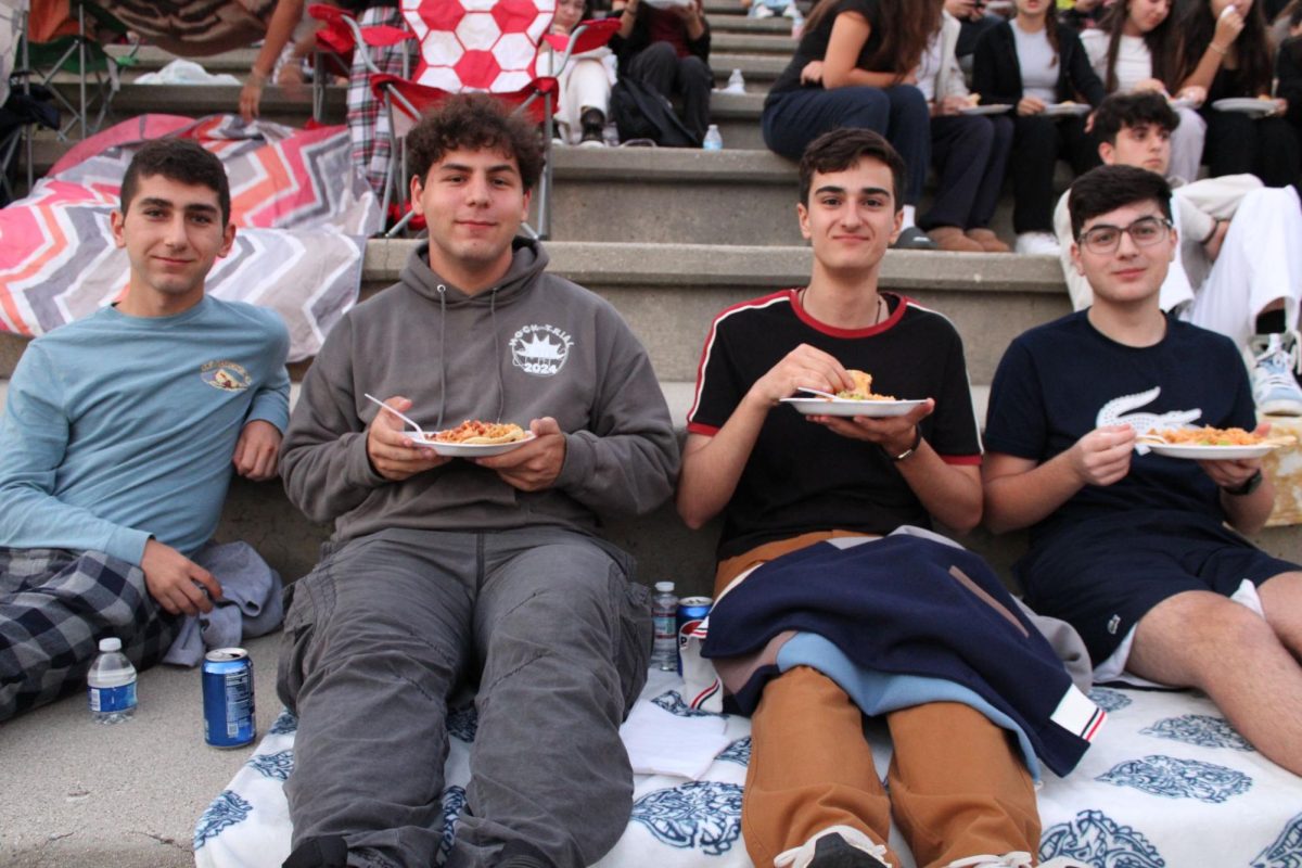 Seniors Sascha Hagobian, Tristan Willstout, Hrachya Hovhannisyan, and Michael Kmbikyan enjoy their tacos on the amphitheater steps, ready for the movie, sitting on the amphitheater steps.