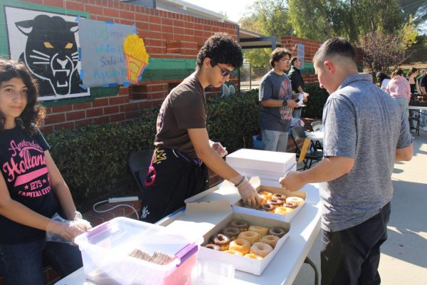 Gardening Club officers Elina Isayan and Narek Harutyunyan selling donuts to Anthony Egoyan.