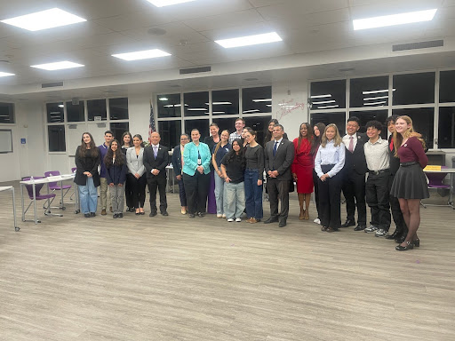 District board members and leaders posing with student panelists. 