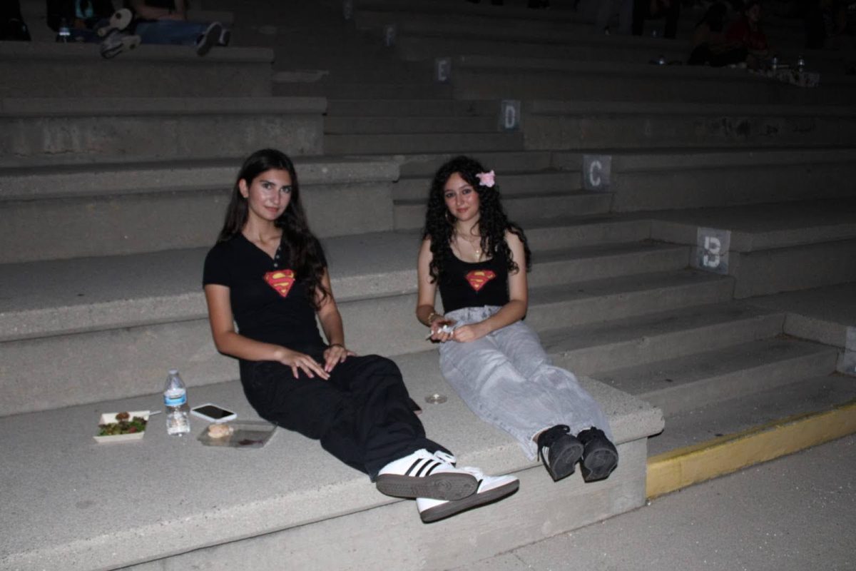 Sophomores Amilia Yadegarian and Emili Shaginian have the Superman logo on their shirts and are eating their sandwiches, excited to watch the movie.