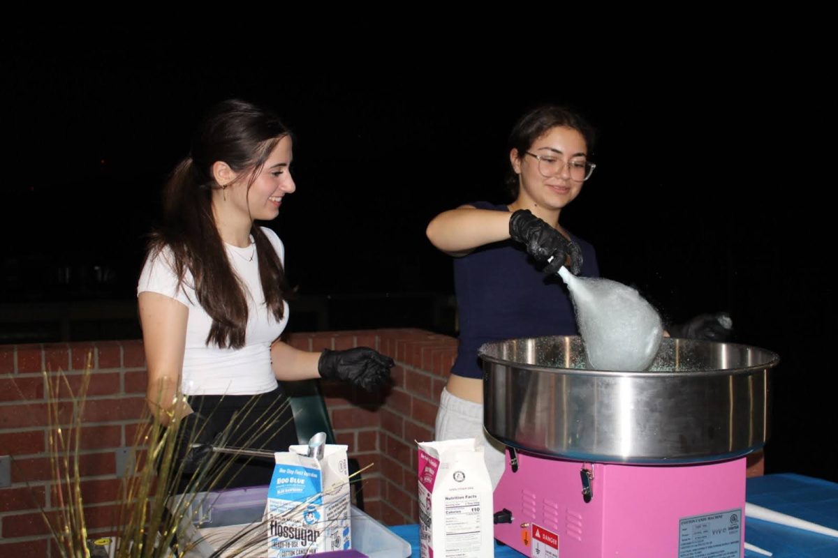  Senior Alina Semerjyan and Junior Anna Meliksetyan making cotton candy for the students to enjoy. 
