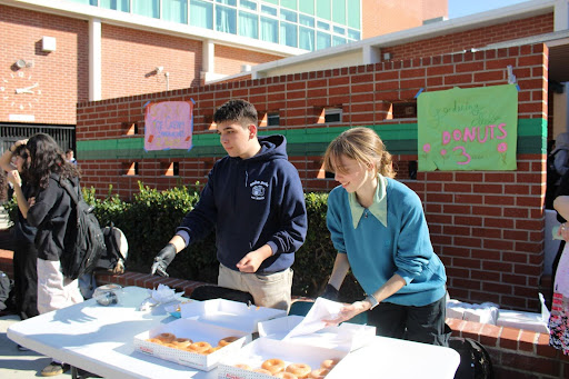 Junior Tigran Akopyan and sophomore Marcelle Danz sell doughnuts to raise money for the Gardening Club.
