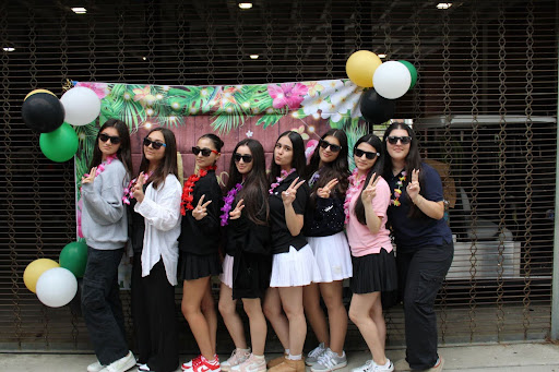 Senior Maria Yervandyan, Emily Titizyan, Emma Hakobyan, Nare Nersissyan,  Nare Khachyan, Agapi Mkrtchyan, Liliana Zaroukian, and Anna Zetilyan posing for a picture in front of the Senior BBQ decorative back drop!