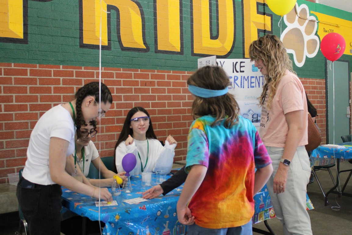 Seniors Lusine Galstyan, Maya Fawaz and Eva Margaryan teach young students about dry ice.